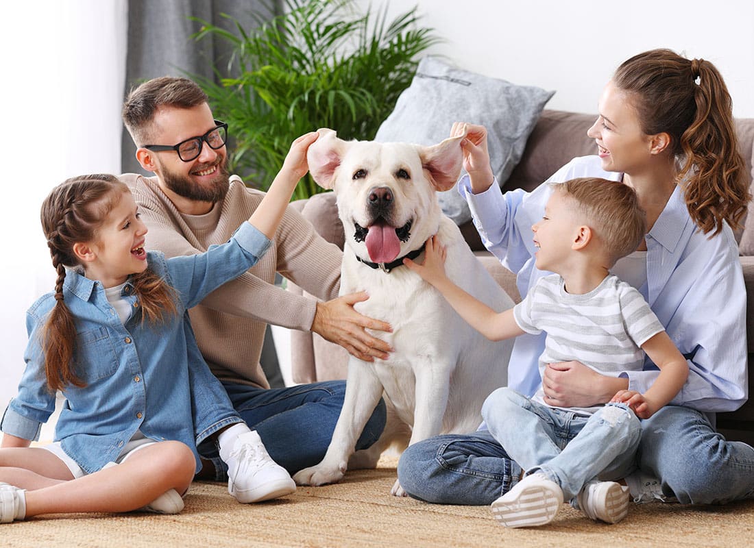 About Our Agency - Family Playing With Dog at Home